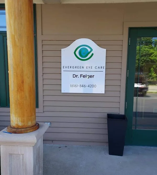 The Evergreen Eye Care entrance plaque beside the green door at 17088 Robbins Rd.